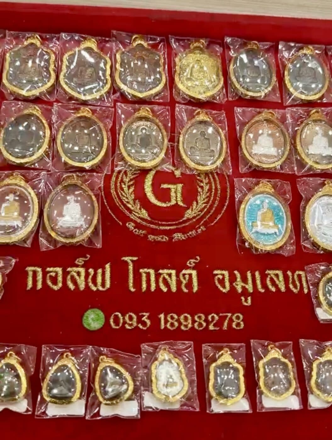พระเครื่องเลี่ยมกรอบทองจัดเรียงบนแผงกำมะหยี่ กอล์ฟ โกลด์ อมูเลท